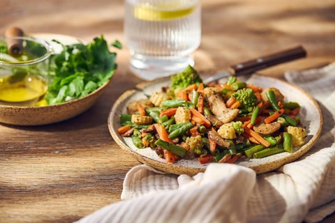 Plate of stir-fried mixed vegetables with green beans, carrots, baby corn, romanesco and mushrooms
