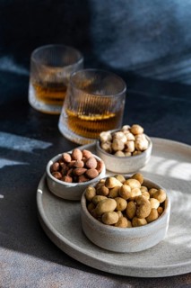 A selection of spiced cognac cocktails, with cinnamon and star anise, accompanied by various nuts