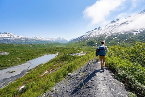 Hikers on glacial moraine, view of the vast Tsina River valley with mountains, Worthington Glacier