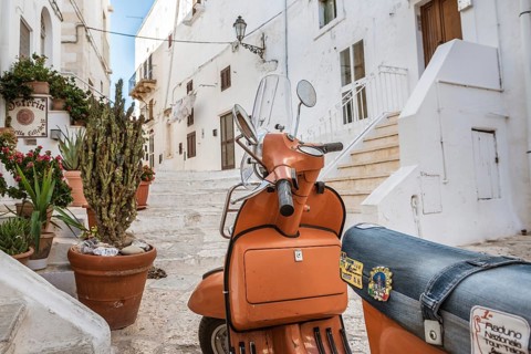OSTUNI, ITALY - SEPTEMBER 26, 2018: Scooter on the pavement in old town. Ostuni is known as the
