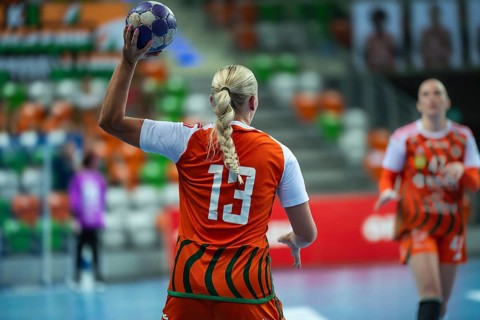Female handball player with blond braid throw the ball in Lubin, Poland