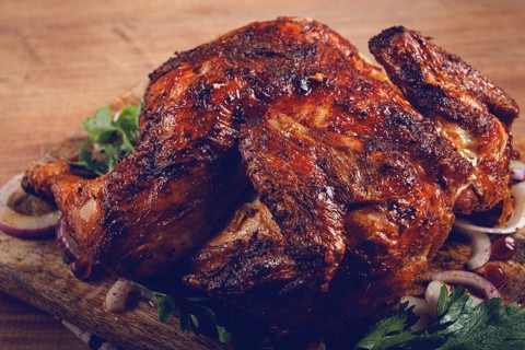 Whole fried chicken, with spices, grilled chicken, on a chopping board, top view, homemade, no