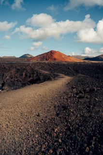 Captivating Lanzarote landscape showcasing volcanic terrain with rusty red hills, rugged lava