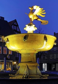 Gilded imperial eagle as a fountain eagle on the market fountain in the evening, Goslar, UNESCO