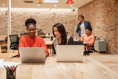 A vibrant coworking space with professionals engaged at laptops, fostering creativity and