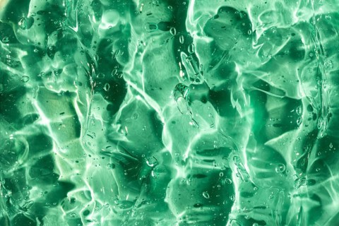 Close-up of a vibrant green gel texture, highlighting its translucent quality and intricate light