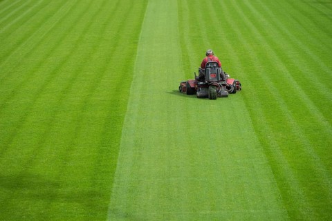 Mowing grass at the football stadium in Lubin, Poland