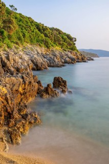 Crystal clear and turquoise water on the beach of Ustrine Bay on a sunny day at sunset on the