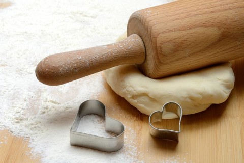 Dough roller on dough and cookie cutter, cake dough