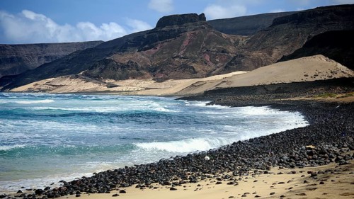 Lonely, secluded rocky coast with waves and mountains, illuminated by the sun, hiking Calhau, Baia