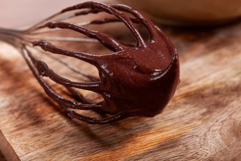 Metal whisk, close-up with chocolate dough, baking, structure and consistency, homemade, top view,
