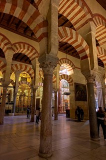 An illuminated area with arches and columns in the Cathedral Mosque of Córdoba (Mezquita-Catedral),