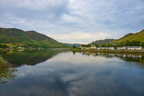 Tranquil seascape with mountains and a small village on the shore under cloudy sky, Dornie, Kyle of