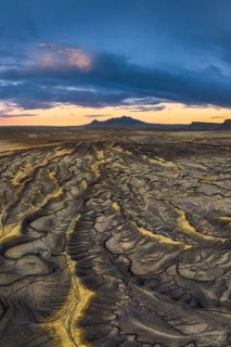 Sunset casts vibrant hues over the intricate, erosion-carved landscape of Factory Butte in Utah,