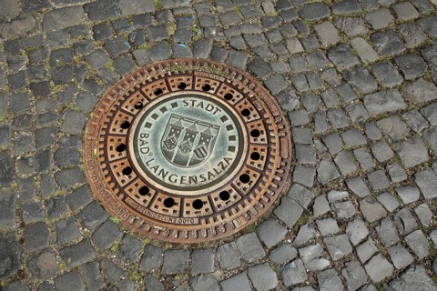 Round manhole cover with city coat of arms and inscription, paving stones, floor, Bad Langensalza,