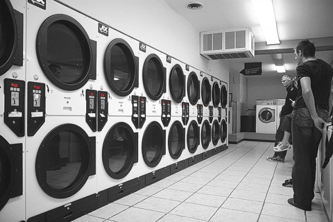 Customers wait for their laundry in a self-service laundromat, black and white, Newton, New Jersey,