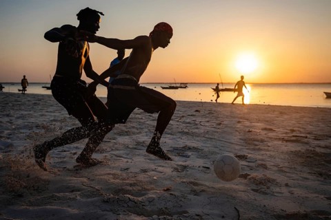 MICHAMVI KAE, ZANZIBAR - OCTOBER 19, 2025: Silhouetted young men play a competitive game of soccer