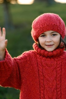 A cheerful young girl wearing a cozy red sweater and hat waves hello during a vibrant autumn day in