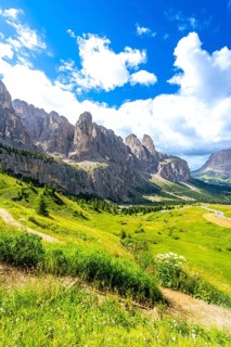 Hiking trail with stunning views of the dolomites mountains and gardena pass on a sunny summer day