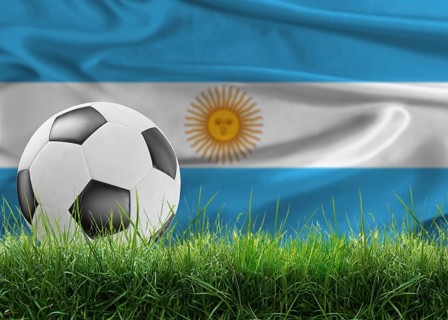Soccer ball on pitch against Argentine flag in the background. Soccer ball on the grass with