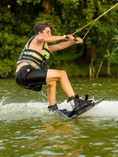 Young man riding wakeboard in lake, Leisure and water sports, Germany