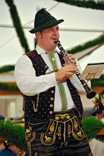 Musician of a Bavarian brass band in traditional traditional costume with lederhosen playing the