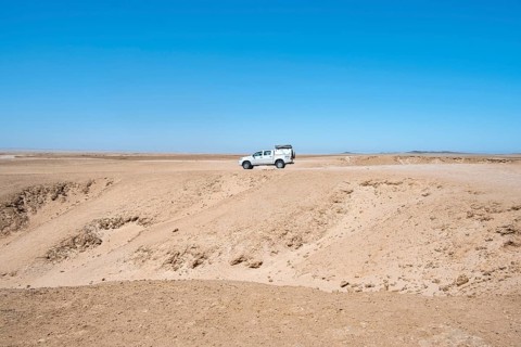 Offroad Car drives trough Rocky landscape, Moon Valley, Namib-Naukluft Park, Namib Desert, Namibia