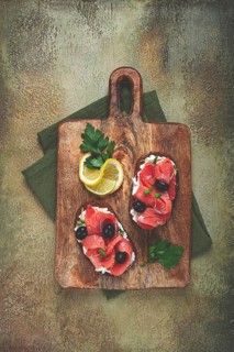 Sandwiches with cream cheese, chum salmon, cold smoked, grain bread, on a cutting board, top view,