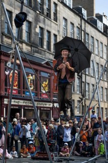 Street performers and spectators at a high-wire acrobatics performance, world's largest cultural