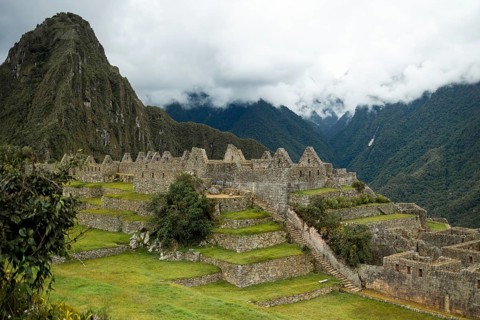A serene view of Machu Picchu, a UNESCO World Heritage site surrounded by lush greenery and a misty