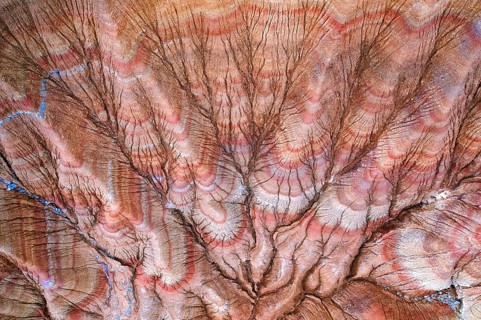 This aerial shot captures a mesmerizing desert landscape marked by intricate erosion patterns and