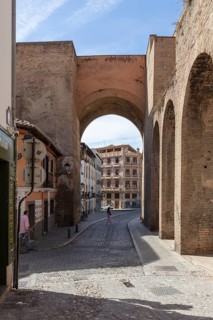 Shady passageway under a stone arch in the old town, Granada