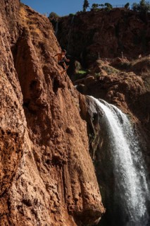 OUZOUD, MOROCCO - OCTOBER 5, 2024: A Moroccan young boy jumps from the high rock into the water