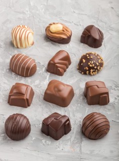 Different chocolate candies on a gray concrete background. side view, close up