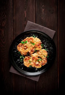 Steak, cauliflower, with cheese, spices, homemade, on a wooden table, dark background, close-up,
