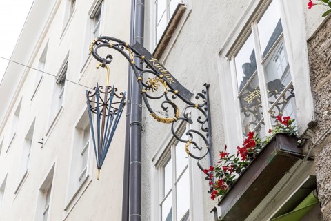 Famous Getreidegasse with umbrella as an advertising figure as a reference to the craftsman, old