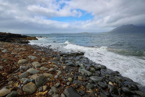 Stormy sea meets rocky coast with mountains and cloudy sky, Elgol Beach, Elgol, Isle of Skye,