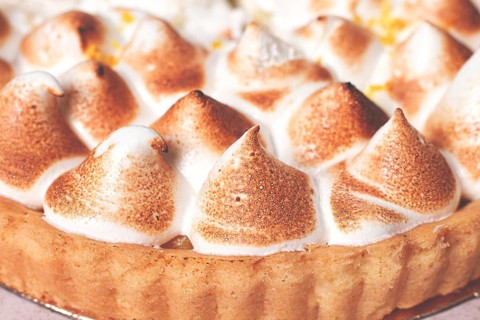 Lemon meringue cake, golden brown, toasted, on a light table, no people