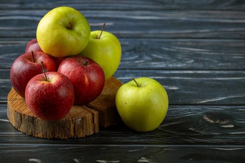 A pile of red and green apples on wood