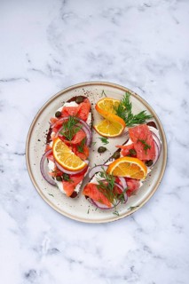 Sandwich with freshly smoked salmon, on black bread, with cottage cheese, with herbs and red