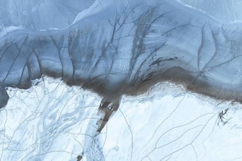 A stunning aerial view showcasing abstract patterns formed by mud and snow in the Arctic region,