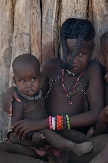 Himba girl with forward braided plaits with baby, near Opuwo, Kaokoveld, Kunene, Namibia