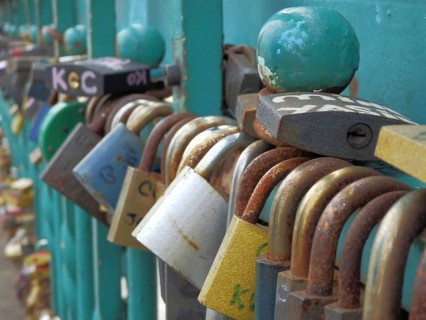 Close-up of rusty padlocks in various colors, attached to the bridge as a symbol of love, Cathedral