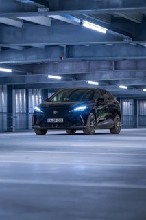A car in a well-lit multi-storey car park with modern architecture, e-car sharing, Deer Mobility,