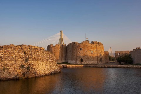 Sea fortress with modern bridge in the background in warm evening light, Rio-Antirrio cable car
