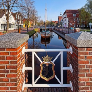 City coat of arms with open-air shipping museum on the main canal, museum ship Frisian Tjalk Thekla