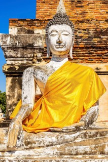 Stone Buddha statue decorated with yellow cloth, historic Buddhist temple complex, Ayutthaya,