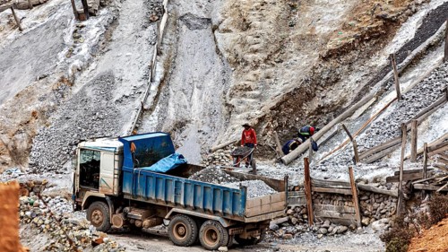 Truck and workers in a steep quarry loading rubble, The silver mines of Potosi on Cerro Rico in