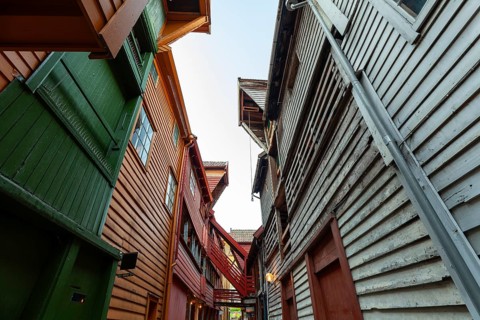 Summer day exploring behind facades in Bryggen Bergen, narrow lanes, colorful wooden buildings,