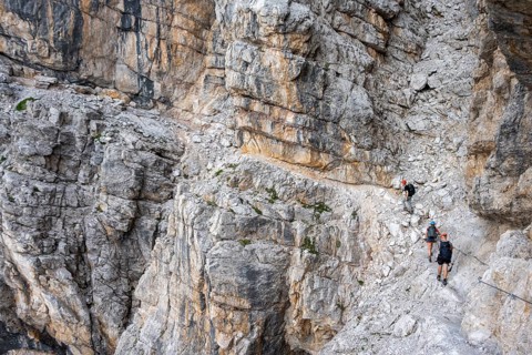 Three hikers on the Via Ferrate Benini via ferrata on a cliff, Brenta Mountains, Parco Naturale